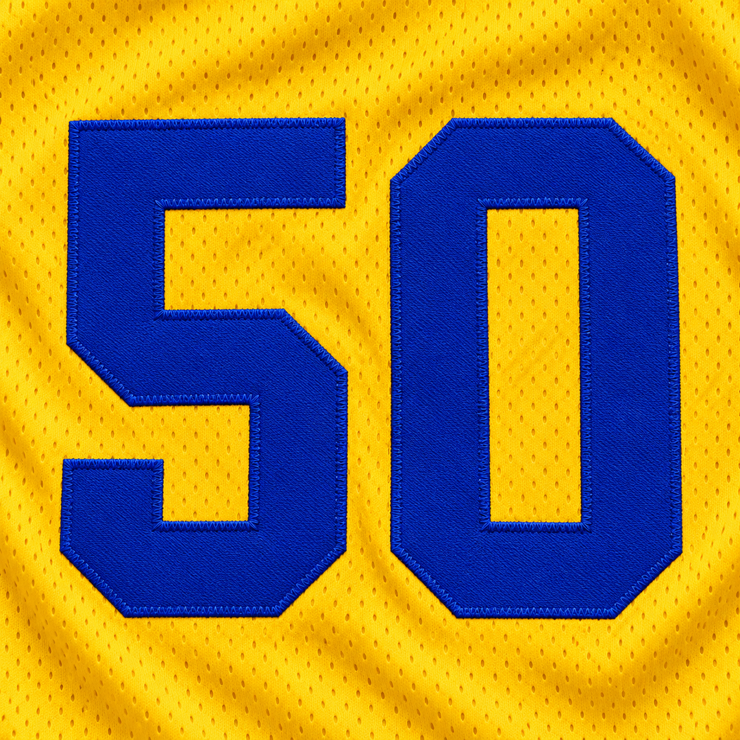 Close-up product mockup of blue number 50 applique with raised stitched edges on yellow mesh basketball jersey fabric.