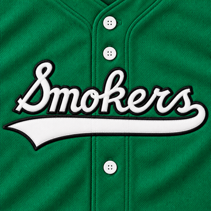 Close-up product mockup of white Smokers script and underline with black embroidered edges on green jersey fabric.
