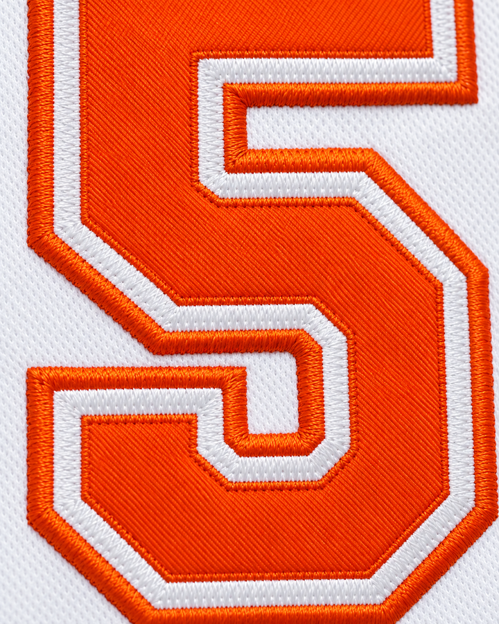 Embroidery detail product mockup of Vakidis 55 Flint Tropics White Semi Pro Basketball Jersey.